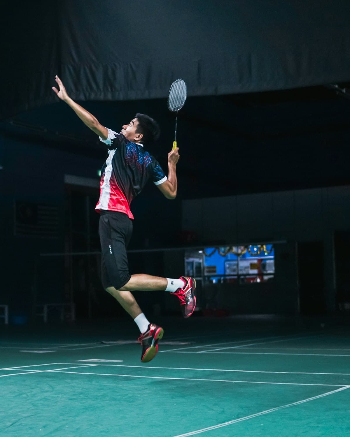 A badminton player mid smash during a match